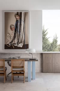 Modern dining room with abstract painting, wooden table, and chairs.