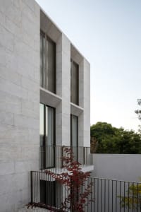 A modern residential building with concrete exterior walls and large windows.