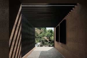 Concrete and steel corridor with garden view, modern architectural design.