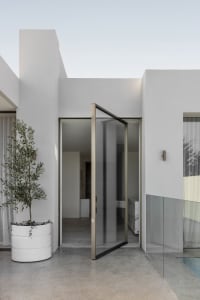 Modern minimalist exterior with glass doors and clean lines.