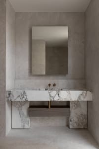 Modern minimalist bathroom with marble finishes and a floating vanity.