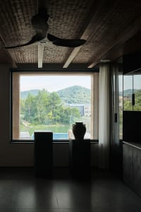 Minimalist residential interior featuring wood, glass, and concrete materials.