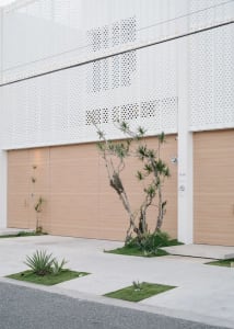 Modern residential exterior with garage doors and minimalist design elements.
