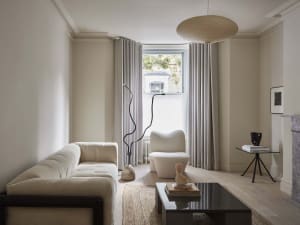 A modern living room featuring a minimalist interior with a bitonish sofa, a cozy armchair, and a sleek side table.