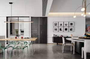 Modern dining room featuring sleek, transparent chairs, a wooden table, and contemporary artwork.