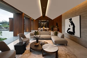 A modern living room with a wooden floor, marble coffee tables, and glass accents.