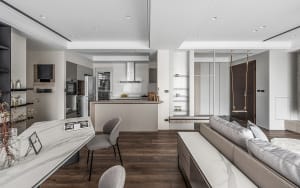 A modern living room with a kitchen counter featuring wood, marble, and metal materials.