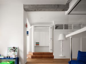 A minimalist white interior with concrete and wooden elements.