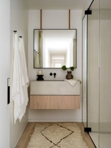 A modern bathroom featuring a concrete vanity and a glass shower door.