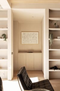 A modern minimalist living room with neutral-colored walls, furniture, and decor.