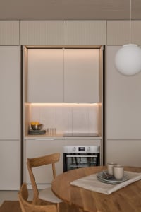 A modern minimalist kitchen featuring concrete countertops and backsplash.