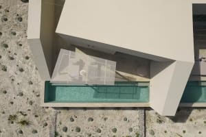 Aerial view of a modern residential layout featuring glass walls and concrete structure.