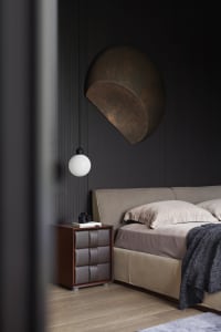 Minimalist bedroom with a bed, nightstand, and wall light fixture