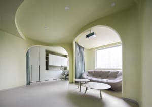 Modern, minimalist living room with white furniture, grey sofa, and white coffee tables.