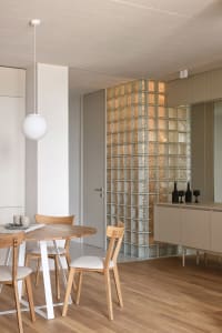 Modern minimalist kitchen featuring glass block walls and wooden furniture.