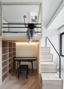A modern living space featuring a floating bed with an integrated desk, stairs, and a piano.