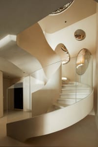 Modern staircase featuring glass railings and concrete steps