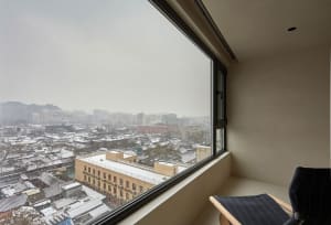 A view through a window of a snowy cityscape.