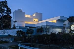 A modern residential house with a unique stepped design featuring concrete and glass materials.