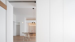 A modern residential dining room with wooden furniture and concrete flooring