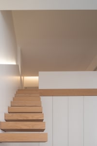 Modern interior design featuring wooden stairs and white walls.
