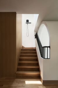 Modern interior design featuring wooden staircase with black railings.