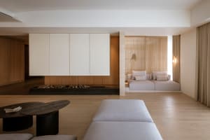 Modern living room featuring two white sofas with light-colored cushions against a wooden background with white paneling on t