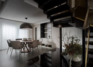 A modern dining room with marble accents, featuring a circular table surrounded by six chairs.