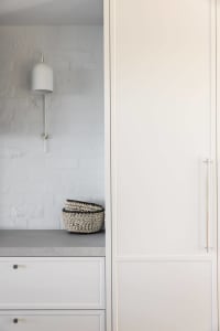 Modern minimalist interior design featuring concrete surfaces and sleek white cabinetry.