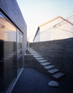 Modern residential exterior featuring brick and concrete elements.