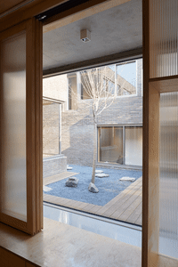 Modern interior with wooden flooring, glass walls, and stone accents.