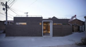 Modern residential home with brick exterior and large windows.