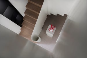 A modern staircase with wooden steps and a concrete handrail