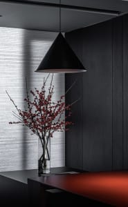 A sleek, modern office space featuring black aluminum panels, a minimalist design, and red accents.