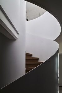 Spiral staircase with wooden steps and white walls