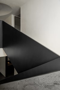 Modern interior design featuring a sleek, black metal staircase leading upwards