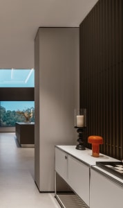 A modern interior space featuring a white wall and wood-paneled wall.