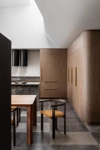 Modern residential kitchen featuring wooden cabinets, marble countertops, and stainless steel appliances.