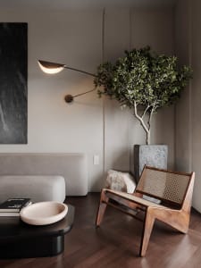 A modern living room featuring upholstered furniture, stone elements, and natural lighting.