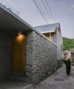 Modern building exterior featuring stone walls and a wooden door.