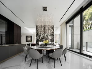 A modern dining room with marble furniture and a chandelier hanging above the table.