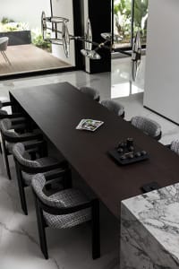 Modern dining room with a dark wooden table, marble floor, and contemporary lighting fixture