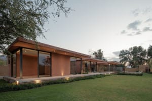 Minimalist residential architecture with clay exterior walls and glass windows.