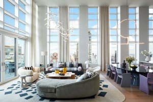 Modern living room with contemporary furniture, large windows, and city view.