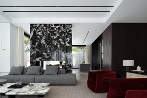 A modern living room featuring a marble fireplace and grey sofa.