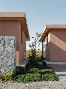 A modern residential exterior featuring clay blocks and a gravel pathway.