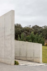 A modern exterior wall made of smooth, light-colored cement with a minimalist design.