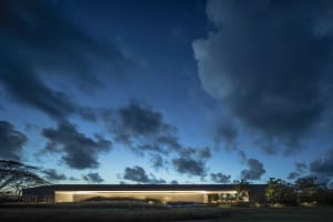 Modern building with large glass windows at dusk.