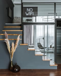 Modern living space featuring a wooden staircase and a glass door leading to another room