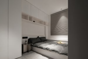 A minimalist bedroom featuring neutral-toned textiles on a built-in bed with integrated storage and a simple headboard